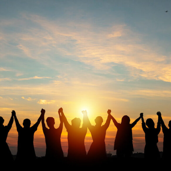 Silhouette of group business team making high hands over head in sunset sky evening time for business success and teamwork concept in company growth mergers and acquisitions start greeting etiquette